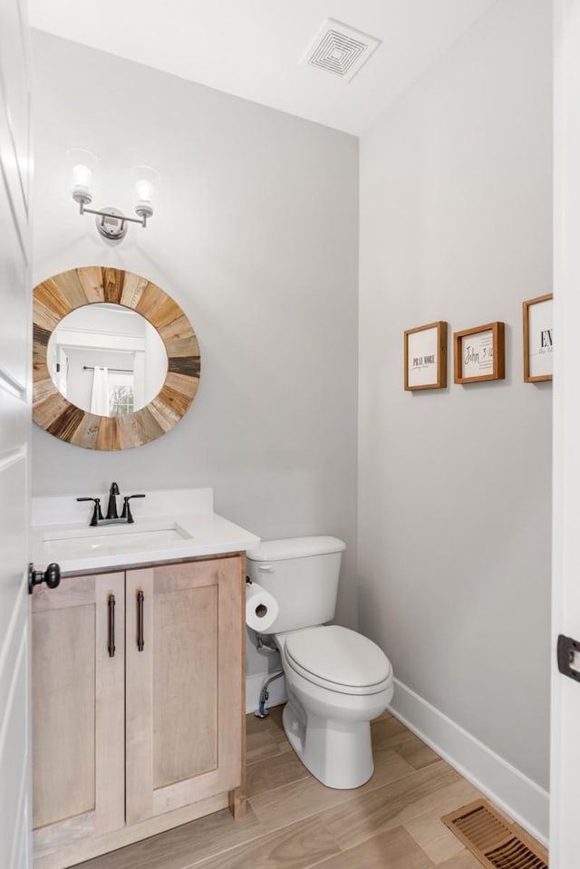 bathroom with vanity, toilet, and hardwood / wood-style floors