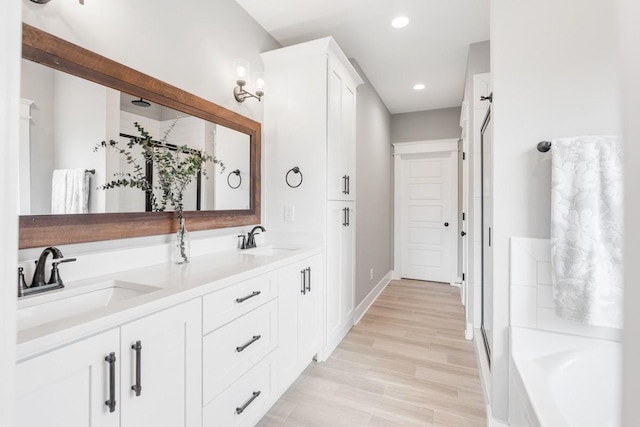 bathroom with hardwood / wood-style flooring, vanity, and separate shower and tub