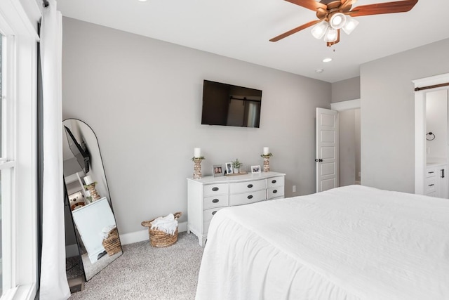 bedroom with ceiling fan, ensuite bathroom, and carpet flooring