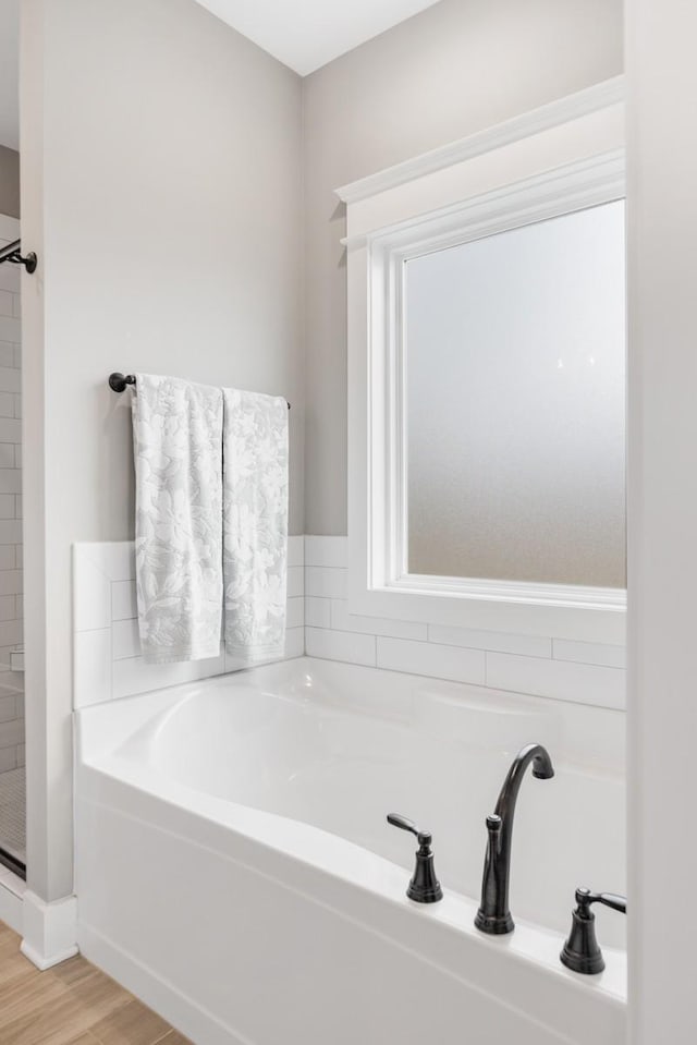 bathroom with independent shower and bath and wood-type flooring