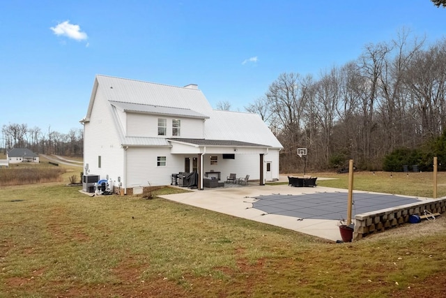 rear view of house featuring a patio area and a lawn