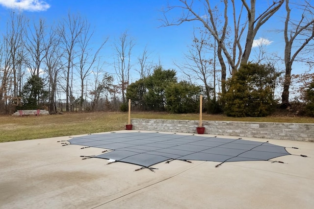 view of pool with a patio and a lawn