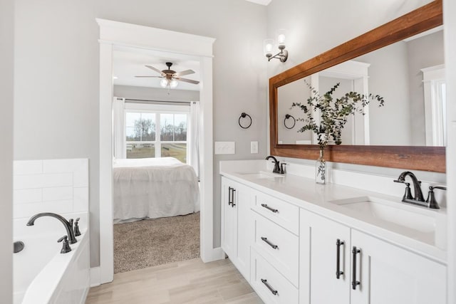 bathroom featuring ceiling fan, vanity, and a bathing tub