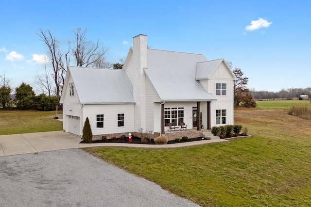 modern farmhouse with a garage, covered porch, and a front yard