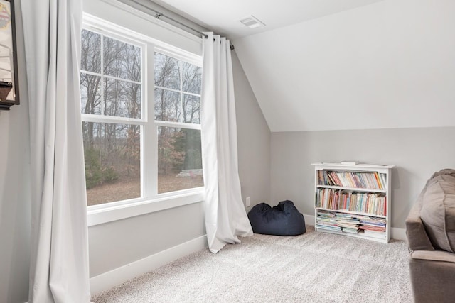 living area featuring vaulted ceiling and carpet