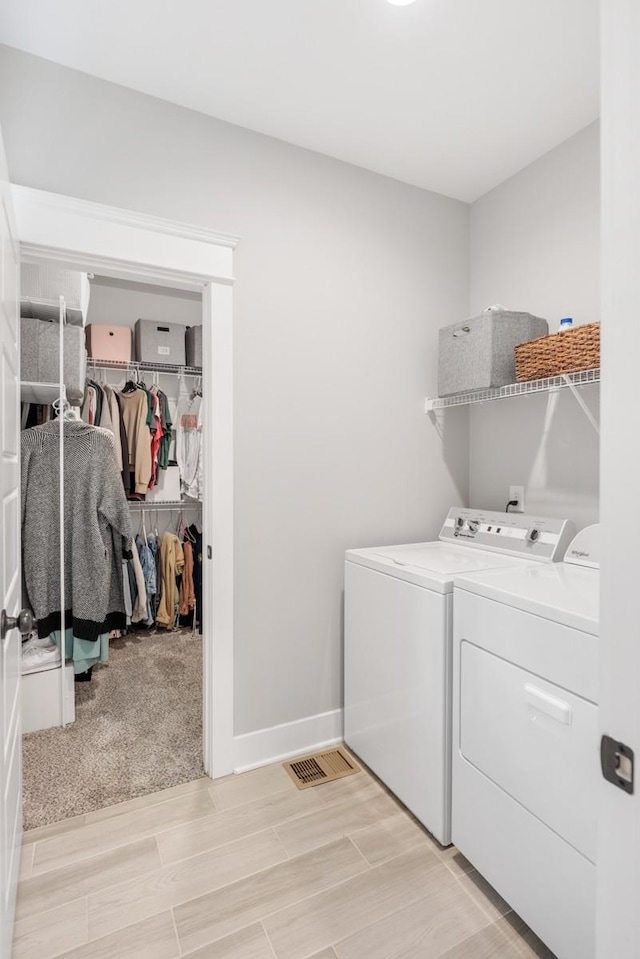 clothes washing area with washer and clothes dryer