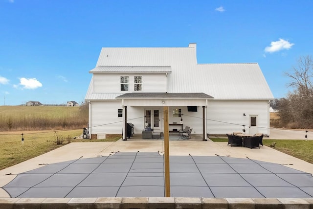 rear view of house with a covered pool and a patio area