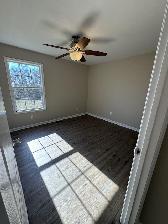 spare room featuring ceiling fan and dark hardwood / wood-style flooring