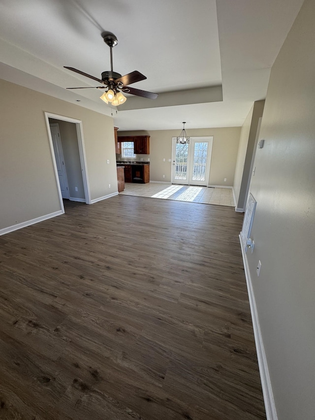 unfurnished living room with dark wood-type flooring and ceiling fan