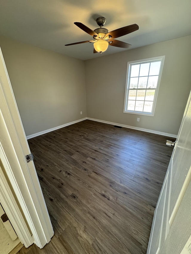 unfurnished room with ceiling fan and dark hardwood / wood-style flooring