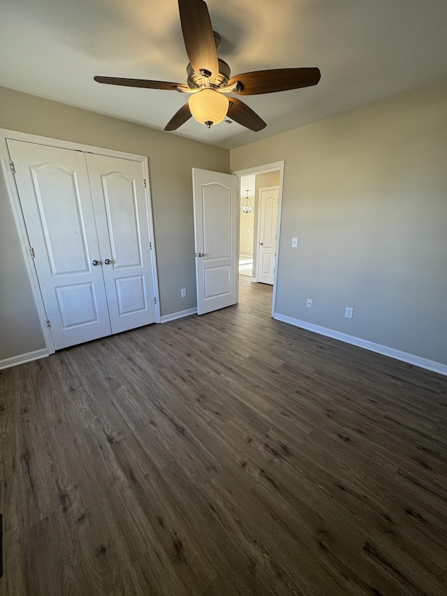 unfurnished bedroom with dark wood-type flooring, a closet, and ceiling fan