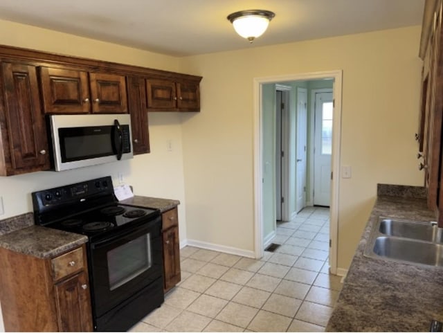 kitchen with sink, black electric range, and light tile patterned floors