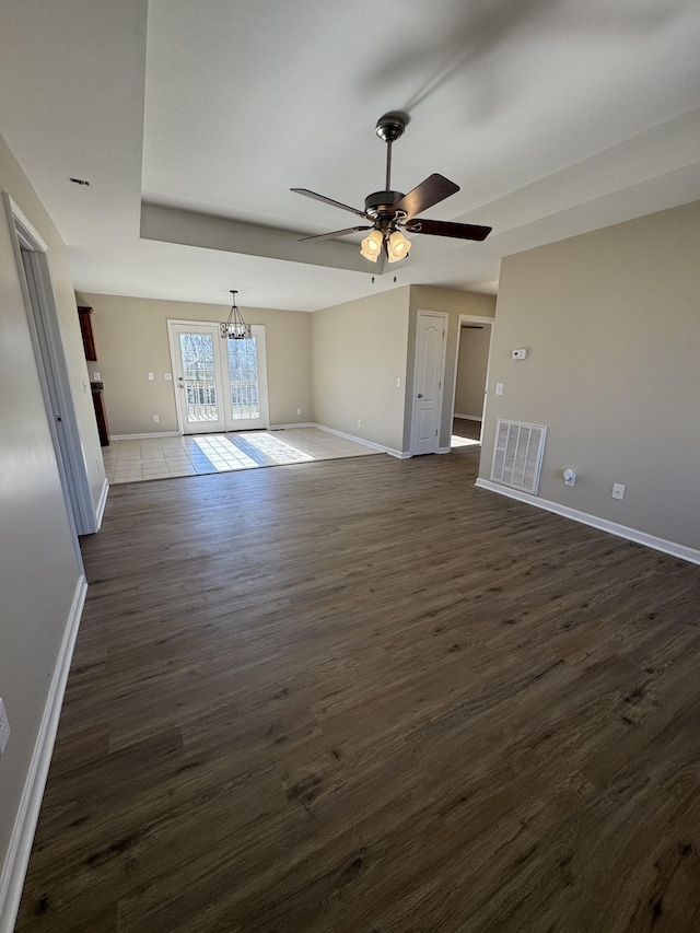 unfurnished living room featuring dark wood-type flooring and ceiling fan with notable chandelier