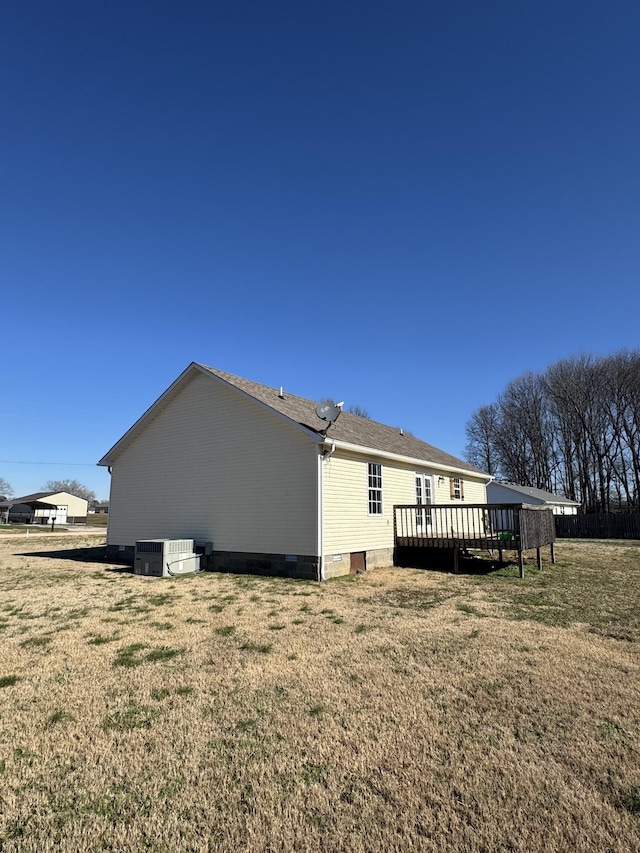 rear view of property featuring a yard, central AC, and a deck