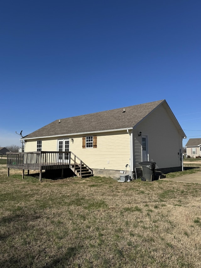 rear view of property with a deck and a lawn