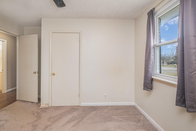 unfurnished bedroom featuring light colored carpet and a textured ceiling