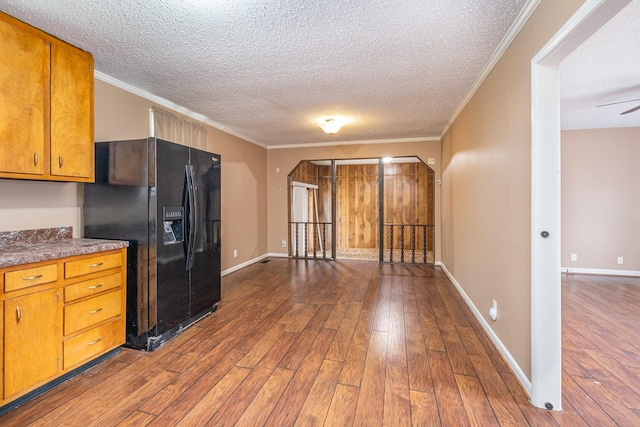 kitchen featuring hardwood / wood-style floors, black refrigerator with ice dispenser, and ornamental molding