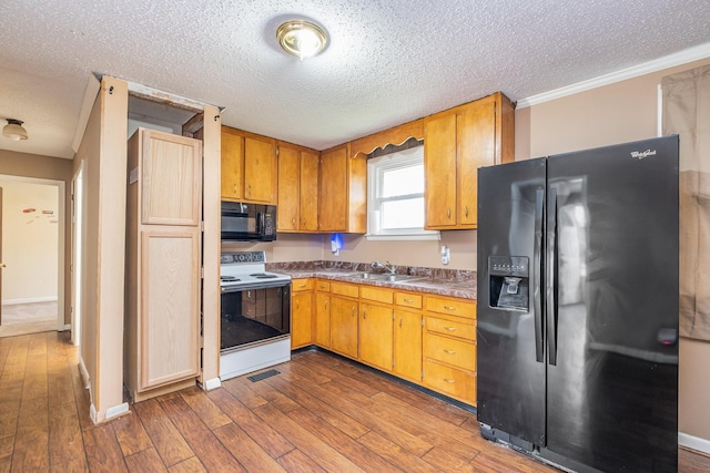 kitchen featuring wood-type flooring, sink, a textured ceiling, and black appliances