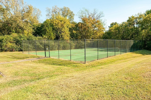 view of tennis court with a yard