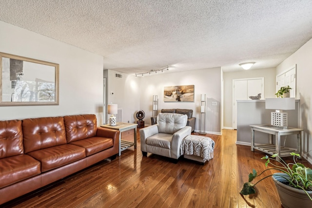 living room with wood-type flooring and a textured ceiling