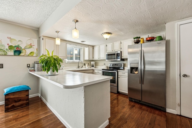 kitchen with pendant lighting, white cabinets, kitchen peninsula, stainless steel appliances, and dark wood-type flooring