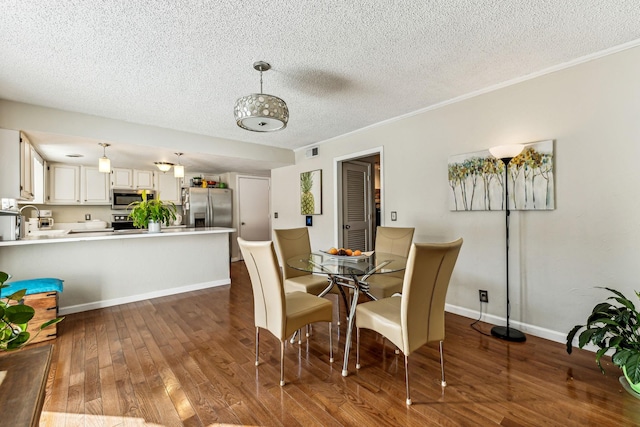 dining area featuring crown molding, dark hardwood / wood-style flooring, and a textured ceiling