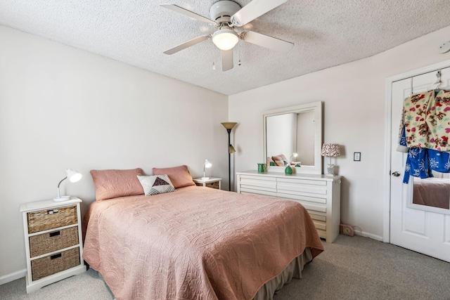 carpeted bedroom featuring ceiling fan and a textured ceiling