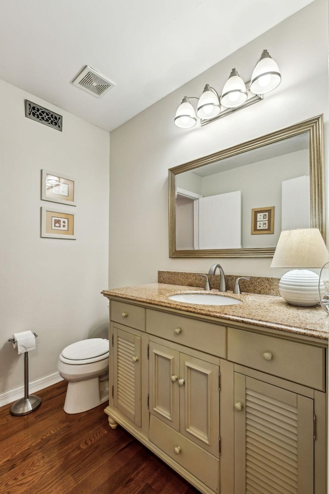 bathroom with vanity, hardwood / wood-style flooring, and toilet