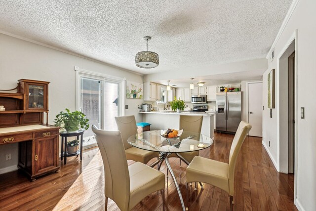 dining space with dark wood-type flooring and a textured ceiling