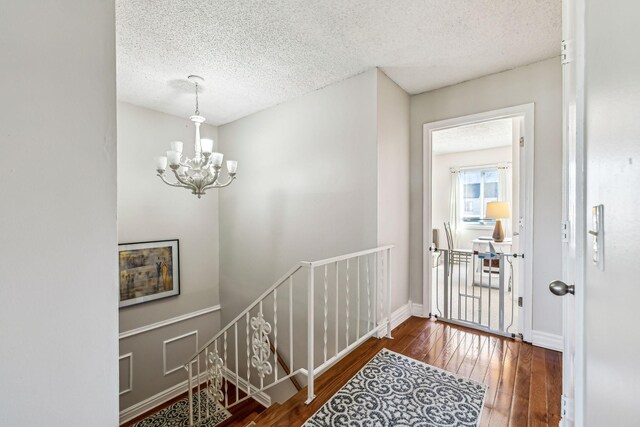 entryway featuring a chandelier, a textured ceiling, and dark hardwood / wood-style flooring