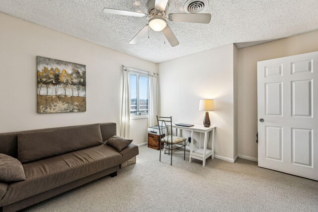 carpeted living room featuring ceiling fan and a textured ceiling