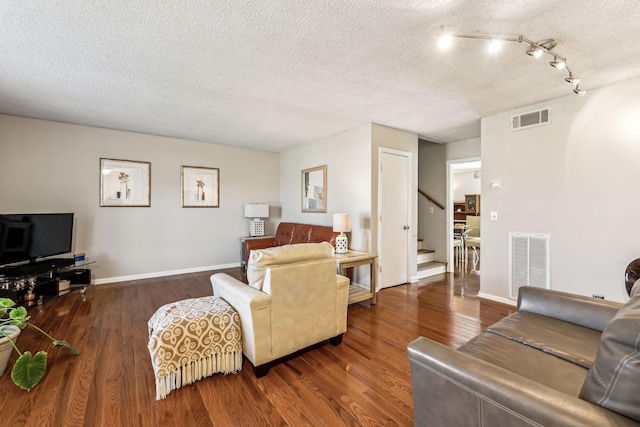 living room with dark hardwood / wood-style flooring and a textured ceiling