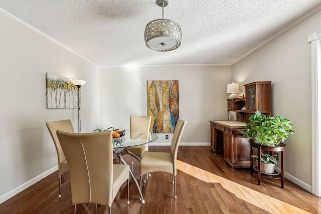 dining area featuring hardwood / wood-style floors, ornamental molding, and a textured ceiling