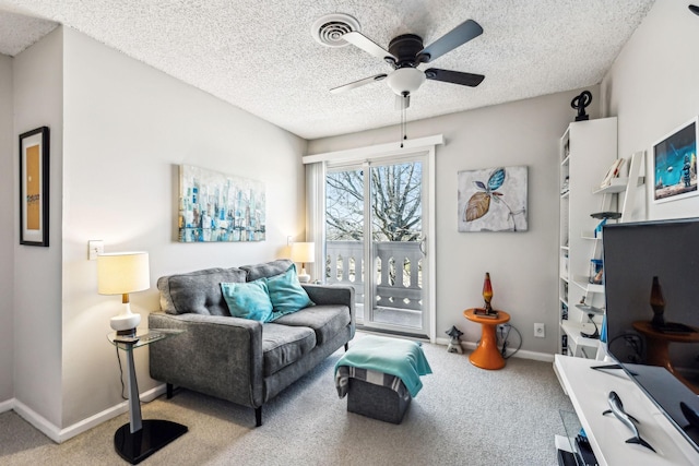 carpeted living room with ceiling fan and a textured ceiling