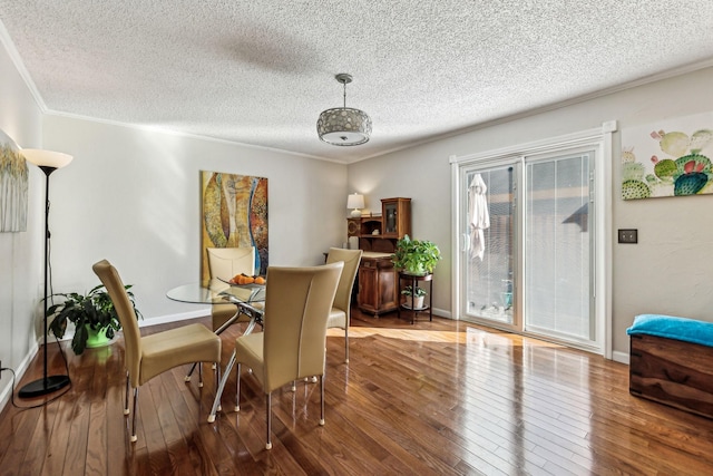 dining room featuring ornamental molding, hardwood / wood-style floors, and a textured ceiling