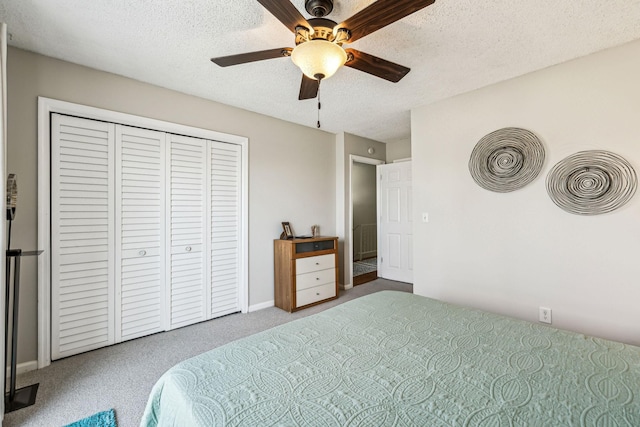 carpeted bedroom with ceiling fan, a closet, and a textured ceiling