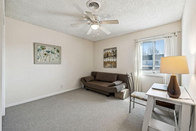 living area with carpet flooring, a textured ceiling, and ceiling fan