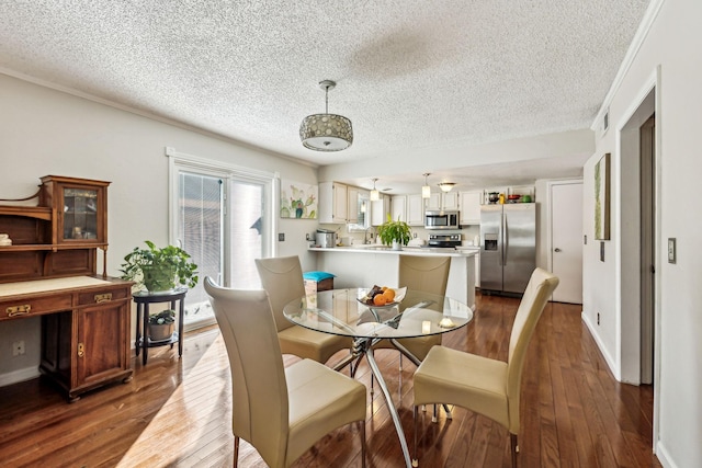 dining room featuring dark wood-type flooring and a textured ceiling