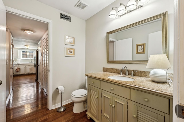 bathroom with hardwood / wood-style flooring, vanity, and toilet