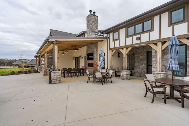 back of property featuring exterior fireplace, a patio, and ceiling fan