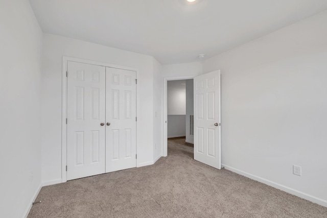 unfurnished bedroom with light carpet and a closet