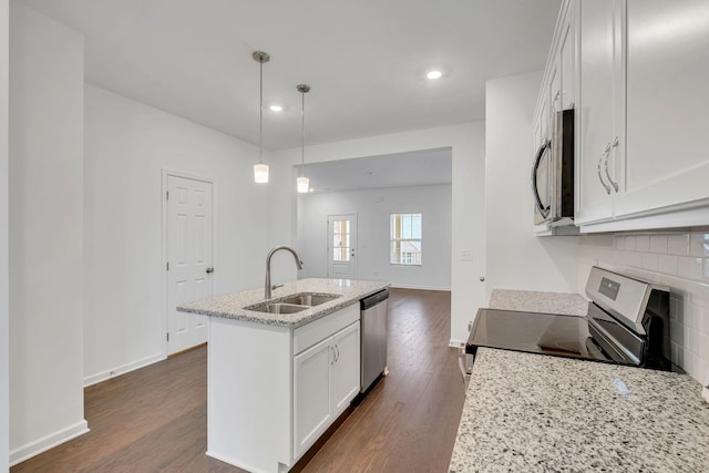 kitchen with sink, appliances with stainless steel finishes, white cabinetry, a kitchen island with sink, and decorative light fixtures