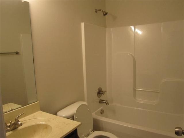 full bathroom featuring vanity, bathing tub / shower combination, and toilet