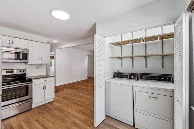 washroom with washer and dryer and light hardwood / wood-style floors