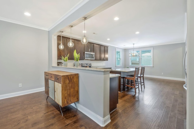 kitchen with ornamental molding, appliances with stainless steel finishes, decorative light fixtures, and kitchen peninsula