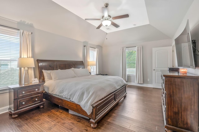 bedroom with dark hardwood / wood-style flooring, vaulted ceiling, and ceiling fan