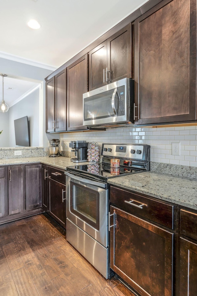 kitchen with crown molding, dark brown cabinets, appliances with stainless steel finishes, dark hardwood / wood-style floors, and backsplash