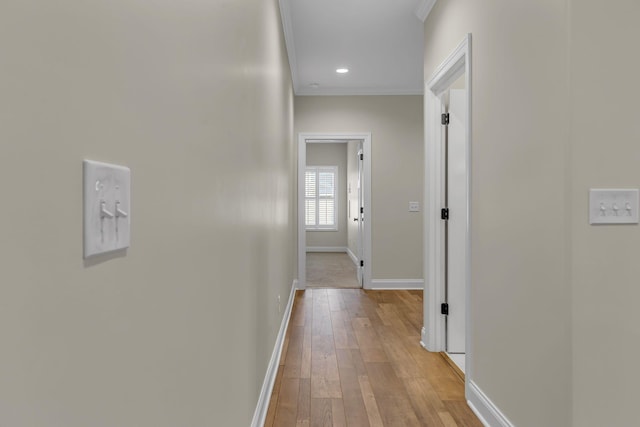 corridor with crown molding and light hardwood / wood-style flooring