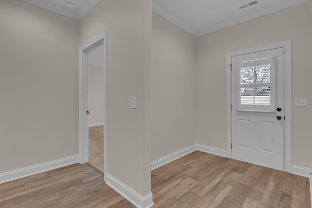 foyer with crown molding and light hardwood / wood-style floors