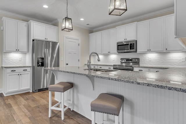 kitchen with sink, stainless steel appliances, white cabinets, and stone countertops